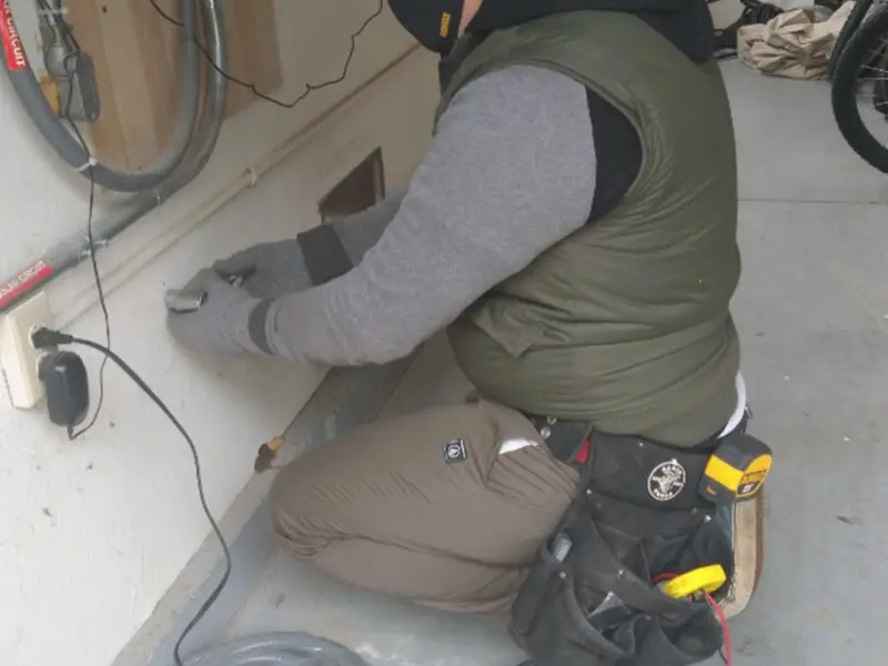 Electrician performing outlet wiring in a Ridge Manor garage